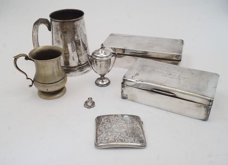 A small group of silver comprising: a cigarette box, of oblong form with hinged lid enclosing wood lined interior, marks rubbed, 18.5cm wide, 9.5cm wide; another cigarette box, Birmingham, 1932, Mayes, Mills & Co., of oblong form, the lid with...