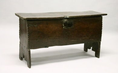 AN 18TH CENTURY OAK SIX PLANK COFFER, with chip carved