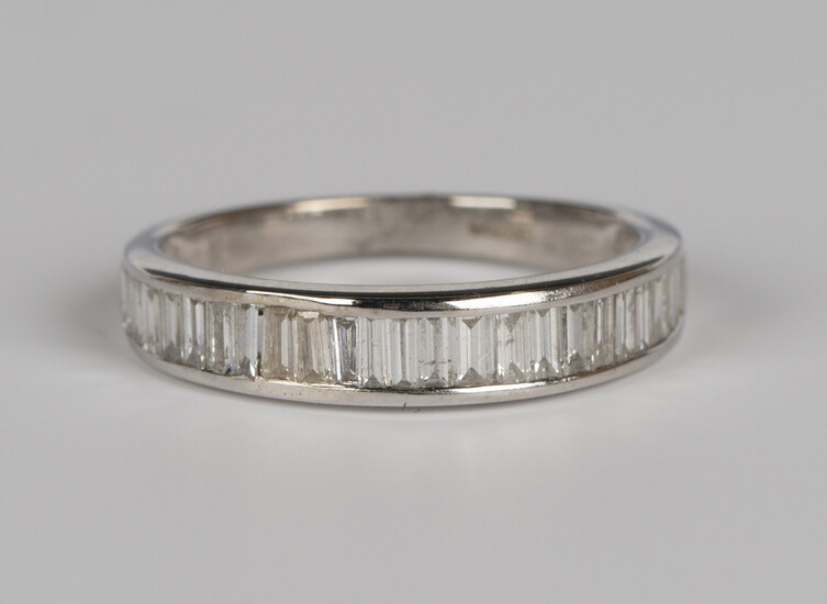 An 18ct white gold and diamond half eternity ring, set with baguette cut diamonds, detailed '75