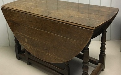 An 18th century oak, planked top, oval gateleg dining table,...