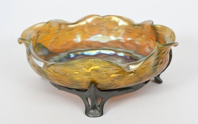 An Art Nouveau pewter mounted Loetz glass bowl, model no. 2210, circular with wavy rim, the bowl with surface textured decoration, covered in a golden iridescence, on pewter tripod foot, stamped marks to pewter 26cm. diam.