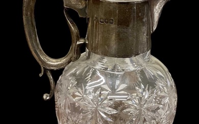 An Edward VII hallmarked silver mounted cut glass claret jug,...