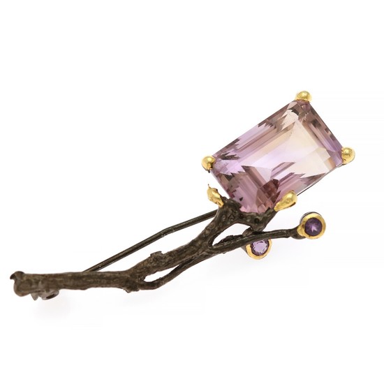 An amethyst brooch set with an emerald-cut and two circular-cut amehysts, mounted in black rhodium plated and partly gilded sterling silver.