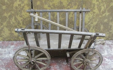 An antique wooden hand cart with open slatted sides and four...