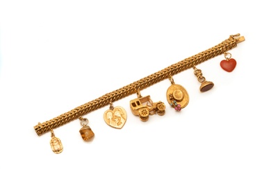 Bracelet en or 750 millièmes, maille gourmette double retenant 7 breloques dont une en or...