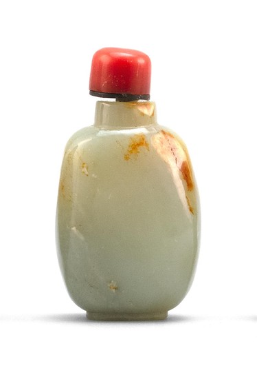 CHINESE CELADON AND RUSSET JADE SNUFF BOTTLE In elongated ovoid form. Height 2.7". Simulated coral stopper.
