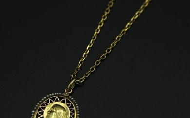 * Chaîne et médaille à l'effigie de la Vierge signée Jener, entourée de perles en or jaune 750 millièmes. Chaîne avec chaînette de sécurité - Poids brut : 16.5 g / L.chaîne 46 cm / Pendentif 36 x 24 mm (manque deux perles)