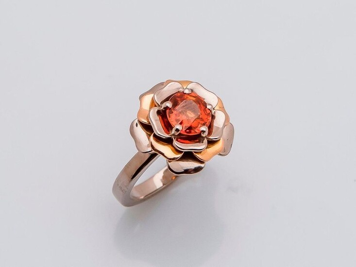 Flower ring in 18 carat white gold and pink gold (750 thousandths) set with a round spesartite garnet in orange color. French work.