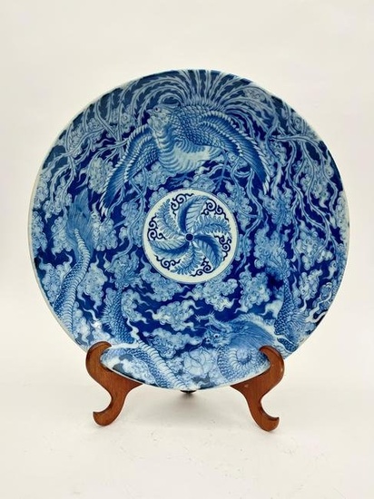 JAPANESE BLUE AND WHITE PORCELAIN CHARGER WITH DECORATION OF MYTHICAL BIRD AND DRAGON AMIDST CLOUD