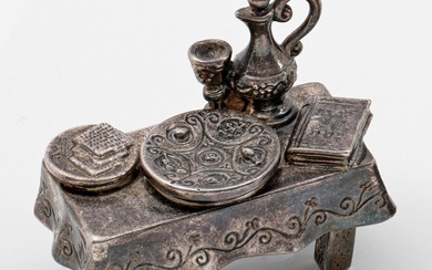 Représentation miniature d'une table dressée Argent massif, lesté. Représentation stylisée en pied d'une table avec...