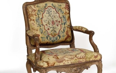 Sculpted beech armchair with a flat shouldered back, decorated with asymmetrical leaf cartouches, rockeries, upholstered with a floral tapestry. Louis XV style Height 102 cm, width 73 cm, depth 60 cm.