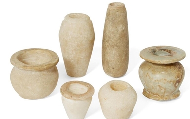 Six Egyptian alabaster vessels Middle Kingdom – New Kingdom, circa 2046-1069 B.C. Comprising a kohl jar with disc rim, 4.6cm high; an alabastron with twin vestigial handles, 8.4cm high; a small piriform jar with flat rim, 3.4cm high; an elongated...