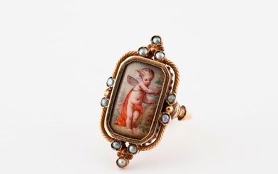 Yellow gold ring (750) set with a miniature on porcelain representing a Love close to a rosebush, in an entourage punctuated with small white mabeled pearls in closed setting.