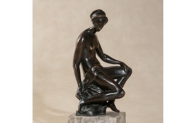 A bronze model of a seated female nude