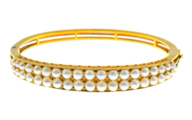 An early 20th century gold split pearl hinged bangle.