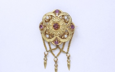 750-thousandths gold brooch, finely guilloché stamped, decorated with faceted round garnets in claw-setting and half-pearls, holding 3 pendants. French work from the second half of the 19th century.