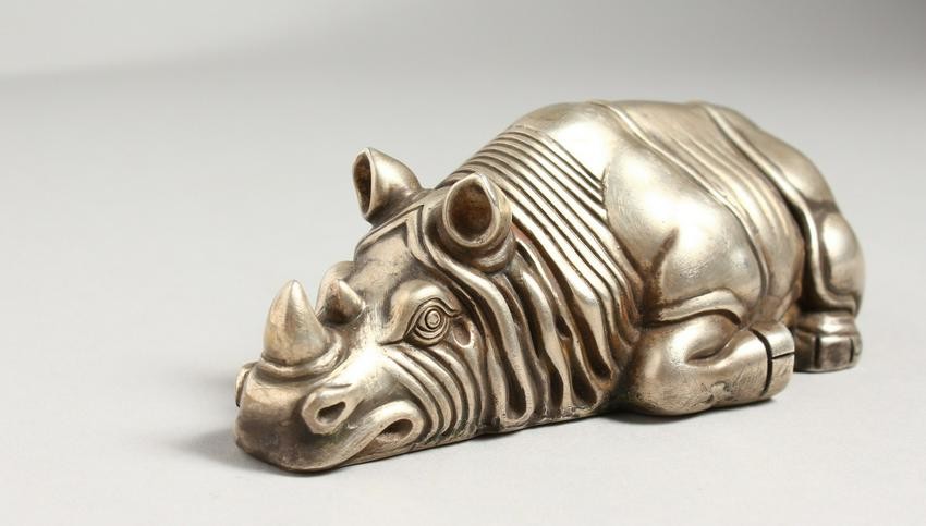 A CAST SILVER MODEL OF A RECUMBENT RHINOCEROS, marks to