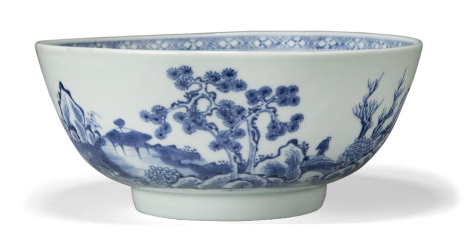 A Chinese porcelain blue and white 'pine tree' bowl excavated from the Nanking Cargo, 18th century, painted with a coastal landscape scene with a lone traveller crossing a bridge amidst pine trees and rockwork, 18.3cm diameter Provenance: Bears...