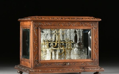 A LATE VICTORIAN CARVED WALNUT AND BEVELED GLASS