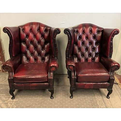 A PAIR OF OXBLOOD CHESTERFIELD WINGBACK ARMCHAIRS, on cabrio...