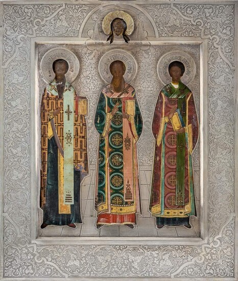 A Russian icon of the Three Hierarchs of Orthodoxy, 1908-1926, marked with 84 standard, Moscow, maker Cyrillic S.G., the three Church Fathers, Basil the Great, Gregory the Theologian, and John Chrysostom, standing full-length wearing elaborately...