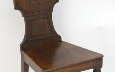 A mid 19thC mahogany hall chair with a shaped backrest