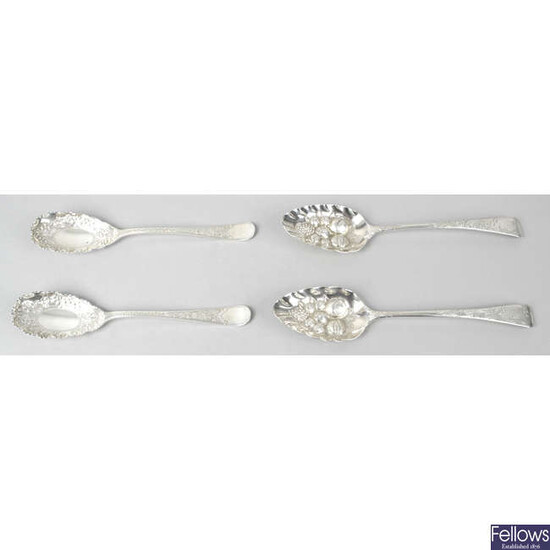 A pair of George IV silver 'berry' table spoons, together with a pair of late Victorian silver fruit serving spoons.