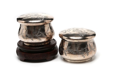 A pair of silver cosmetic covered boxes decorated with floral vine scrolls