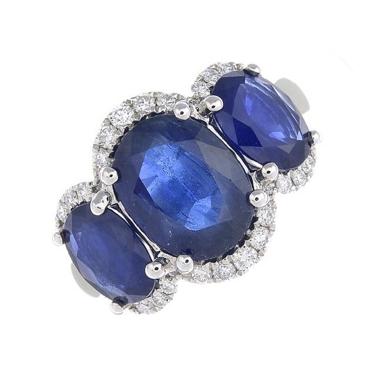 A sapphire three-stone and diamond ring. The graduated