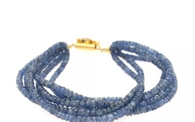 A six strand sapphire bracelet set with numerous sapphires and with a clasp set with a sapphire and two diamonds, mounted in 14k gold.