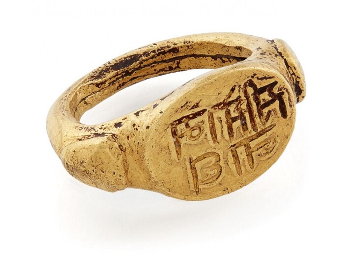 A very rare early gold ring inscribed "Sri Somanath" (Lord Shiva), South India, 10th-11th century, with raised triangular elements to shoulders, the flat oval bezel inscribed and filled with black substance to enhance the inscription, the band...