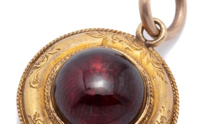 AN ANTIQUE 15CT GOLD GARNET LOCKET; set with a round cabochon garnet to decorative engraved border with wire twist edge having a loc...