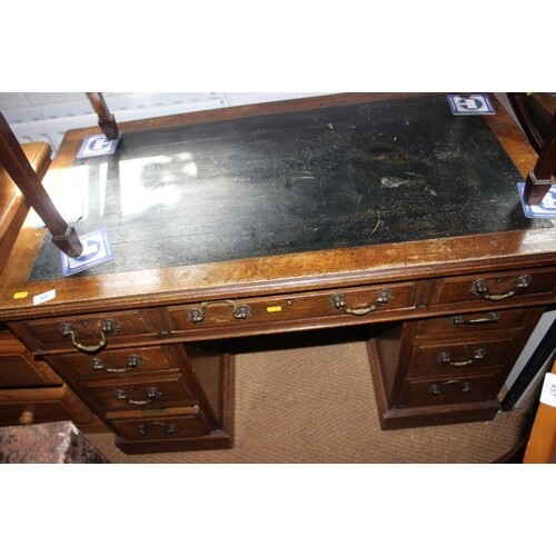 An Edwardian oak double pedestal desk with tooled lined top,...