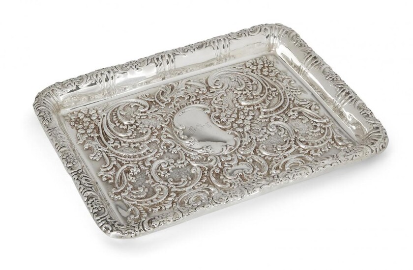 An Edwardian silver tray, Birmingham, c.1902, Thomas Latham & Ernest Morton, of rectangular form, the sides and base richly repousse decorated with scrolls and flowers, the base with monogrammed cartouche to centre, 26.3cm long, 10.9oz