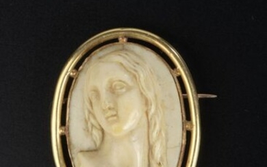 Oval ivory brooch featuring a three-quarter female bust in high relief, the setting in 14k yellow gold.