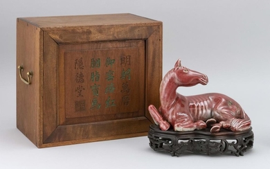 CHINESE PEACHBLOOM GLAZE PORCELAIN FIGURE OF A RECLINING HORSE Length 9". With wooden stand and fitted carrying case with calligraph...