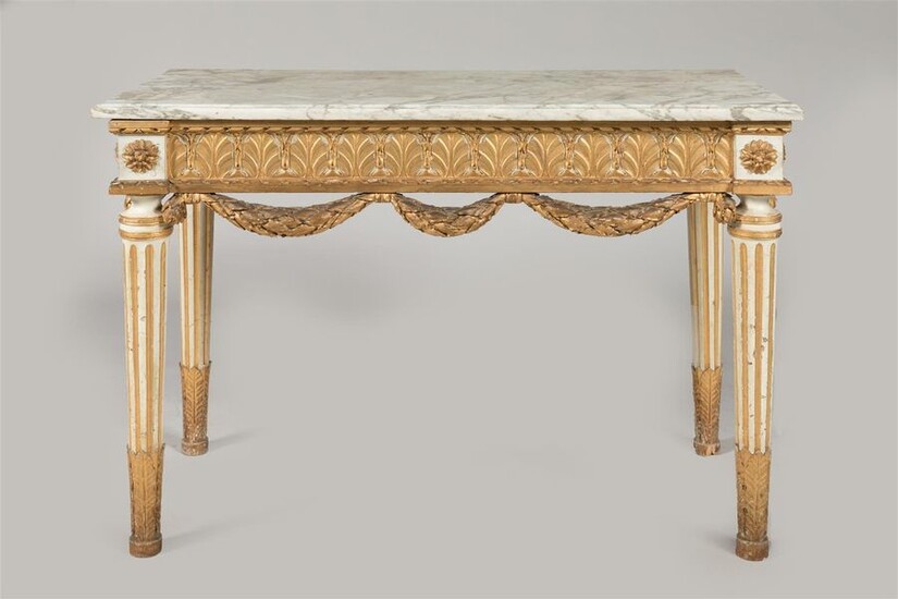 CONSOLE in carved wood, gilded and rechampi, with alternating foliage decoration and oak garlands, resting on tapered, fluted, acanthus-leafed feet. Top in veined Carrara marble. Louis XVI period. 83 x 116 x 55 cm. Accidents and restorations.