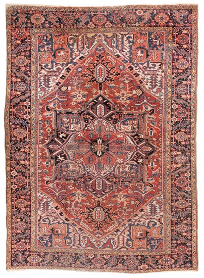 ORIENTAL RUG: HERIZ 8'2" x 11'3" Central red, ivory and navy blue gabled medallion on a rust red field above an ivory subfield with..
