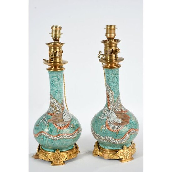 PAIR OF PLEASANT Porcelain VASES mounted as a dragon patterned lamp in the middle of a leafy landscape. Gilded bronze frames with floral and stylized decoration. Ep.XIXth. H.51.