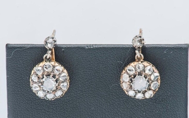 Pair of 18 karat (750 thousandths) yellow gold sleepers, each adorned with a rose-cut diamond surrounded by smaller diamonds and surmounted by a rose.