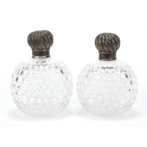 Pair of Victorian cut glass scent bottles with silver lids b...