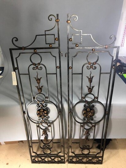 Pair of wrought iron apartment grills opening to two leaves decorated with floral bundles and leaves in gilded cut sheet metal. 20th century.