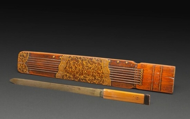 RARE REPOSE-POIGNET en bambou sculpté et patiné, reprenant la forme et le décor d'un koto, et faisant office de fourreau à un...