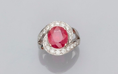 Ring in white gold, 750 MM, centered of an oval ruby weighing 4.43 carats in a coil of brilliants, total about 1 carat, size: 52, weight: 8.9gr. gross.