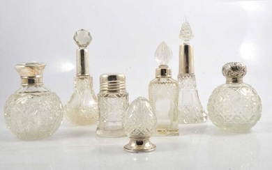 UPDATED - A silver-bottomed pepperette and six silver-topped / collared cut glass scent bottles.