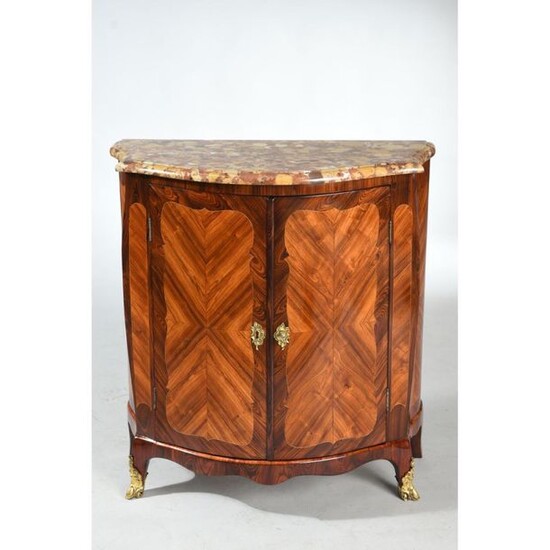 TRANSITIONAL SUPPORT FURNITURE with curved front and flared sides in rosewood veneer with violet wood frame. It opens by 2 doors framed with pinched ribs. Small curved legs. Ornamentation of gilded bronzes. Top in Breche d'Alep marble. Ep.18th century...