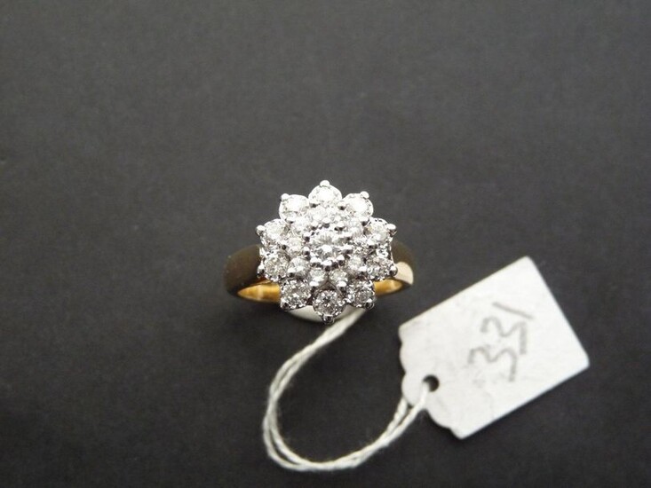 Two-tone 18K (750/oo) gold ring centered on a floral motif...