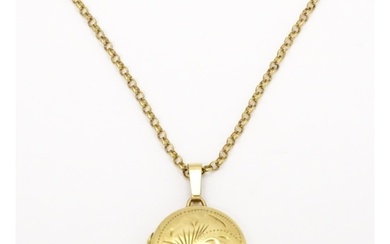 A 9ct gold locket with engraved detail on a 9ct gold chain. ...