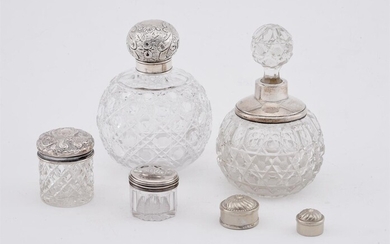 A GROUP OF SILVER MOUNTED CUT GLASS COSMETICS BOTTLES AND JARS