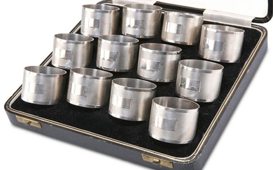 A SET OF TWELVE GEORGE V SILVER NAPKIN RINGS, by Joseph